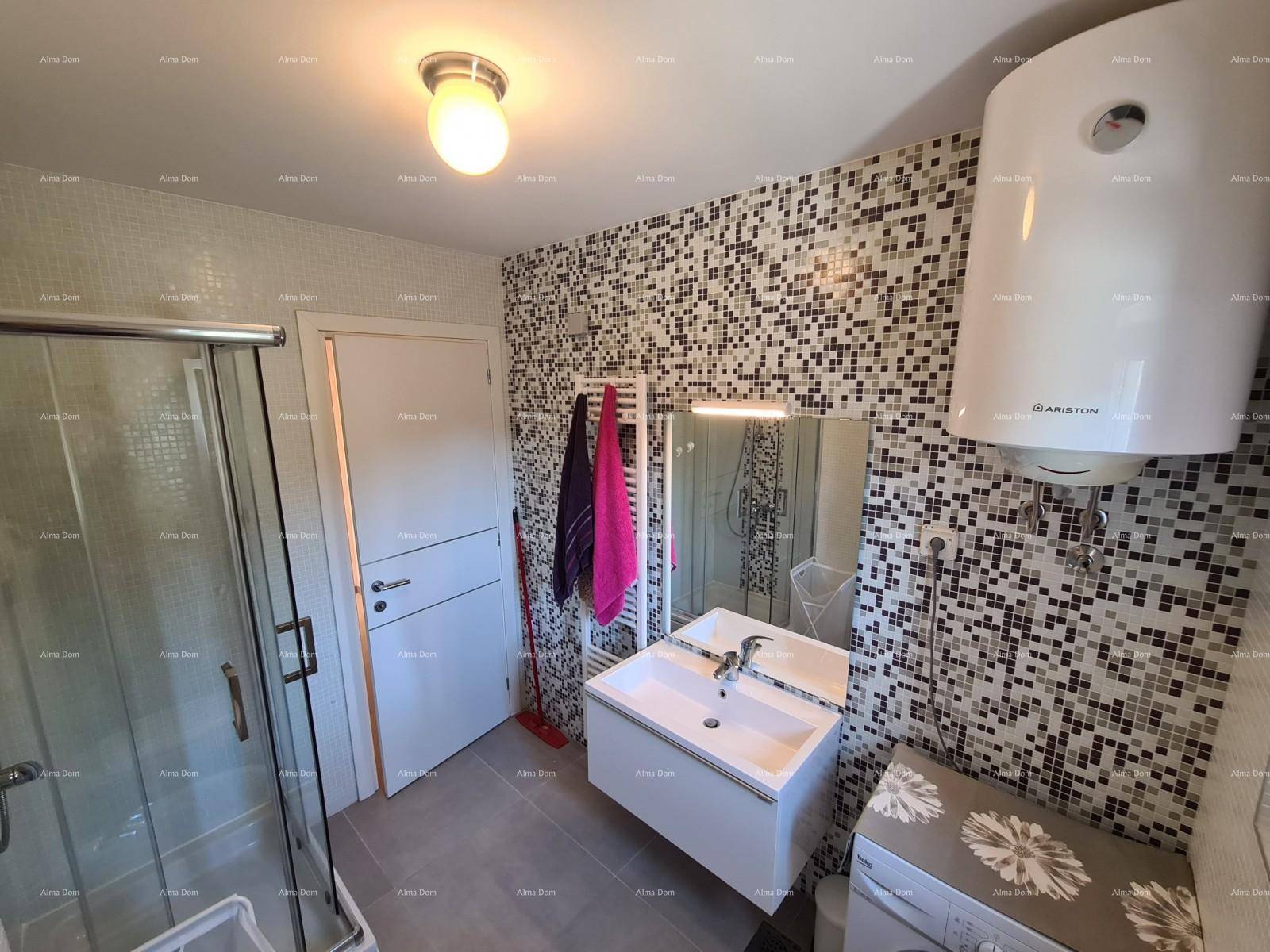 Badezimmer mit Duschkabine, Waschbecken und Mosaikfliesen an der Wand.