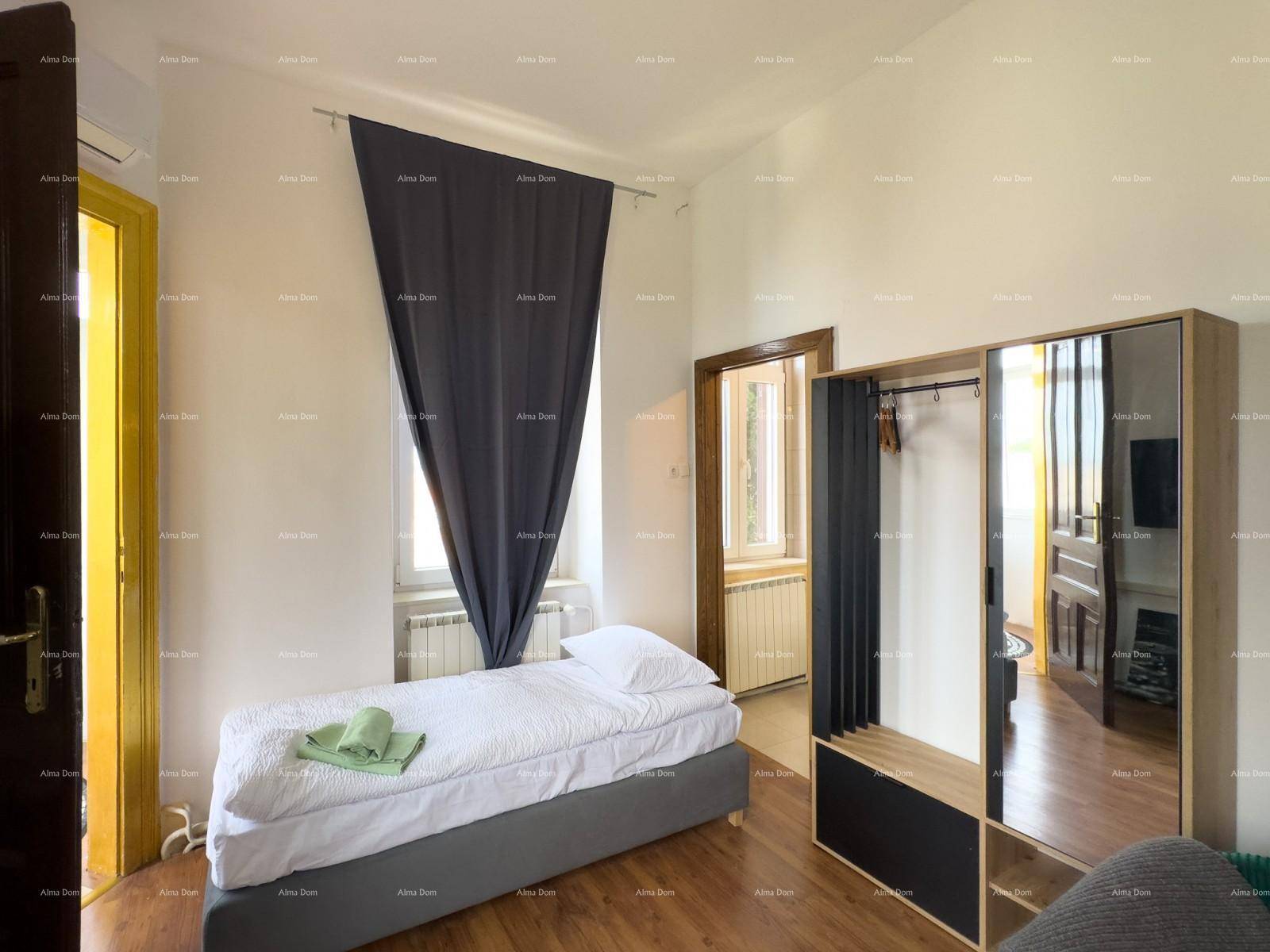 Helles Schlafzimmer mit Einzelbett, Kleiderschrank und Holzboden, ausgestattet mit Klimaanlage.