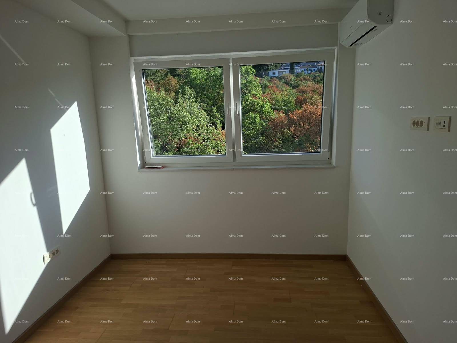 Schlafzimmer mit Holzboden, Klimaanlage und Fenster mit Blick ins Grüne.