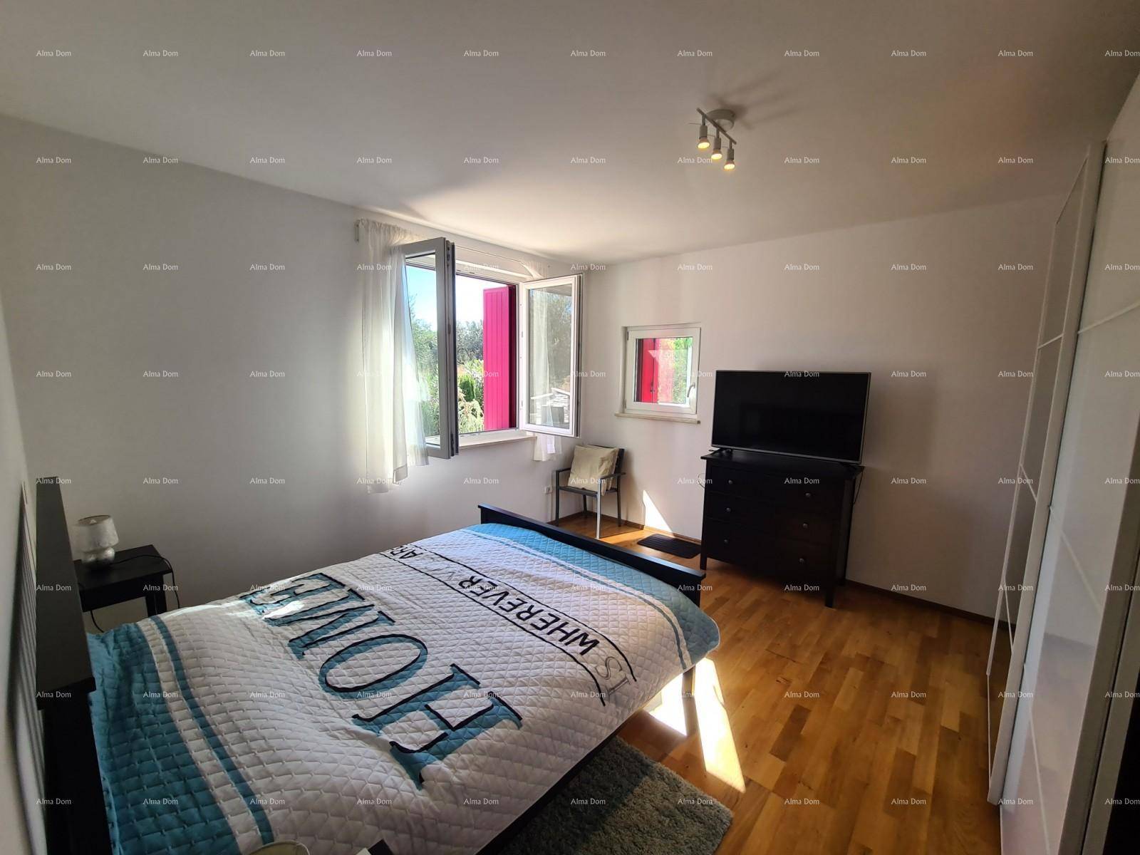 Schlafzimmer mit Doppelbett, Holzparkett und großen Fenstern für viel Tageslicht.