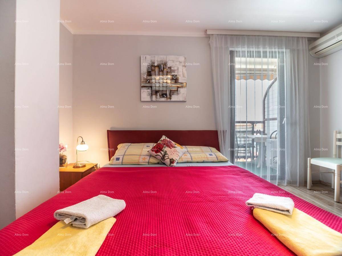 Nahaufnahme des Doppelbettes in einem hellen Schlafzimmer mit Balkonzugang und Klimaanlage.