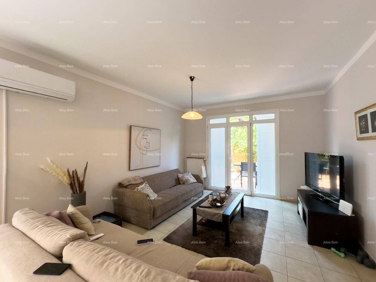 Gemütliches Wohnzimmer mit bequemen Sofas, Fernseher und Zugang zur Terrasse, klimatisiert.