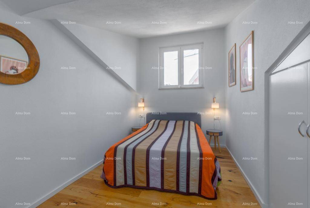 Gemütliches Schlafzimmer mit Doppelbett, Holzboden, Fenster und Dachschräge.