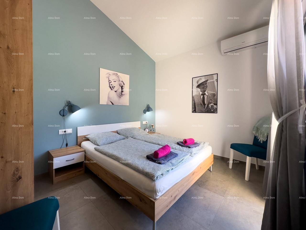 Modernes Schlafzimmer mit Doppelbett, blauer Akzentwand und Klimaanlage.