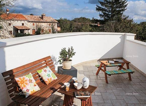 Sonnige Terrasse mit Sitzgelegenheiten und einem weiten Blick auf die umliegende Landschaft und Gebäude.