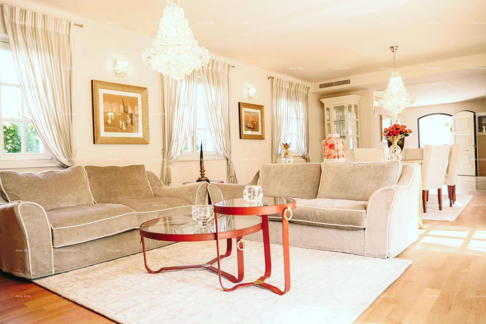 Elegantes Wohnzimmer mit beigen Sofas, modernen Couchtischen und viel Tageslicht.