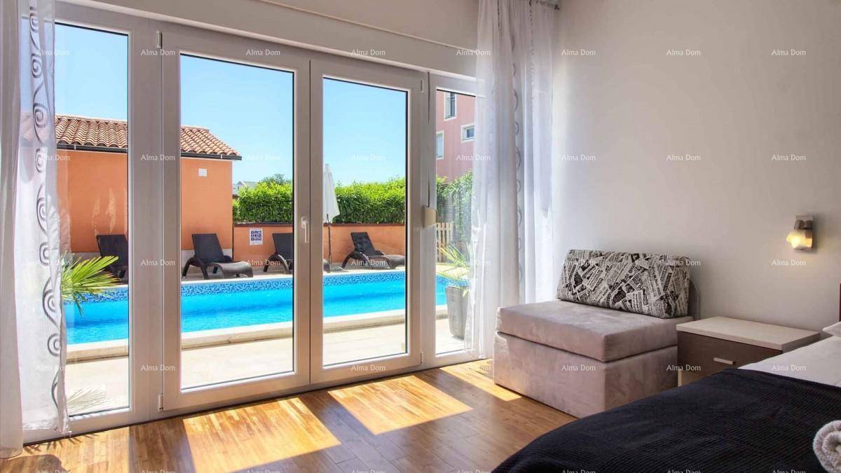Schlafzimmer mit Holzboden und großen Glastüren, die direkten Zugang zum Poolbereich bieten.