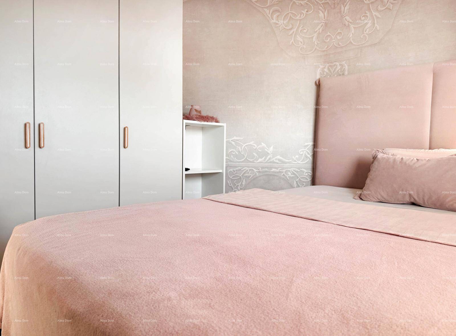 Schlafzimmer mit großem Bett, rosa Bettwäsche und weißem Kleiderschrank.