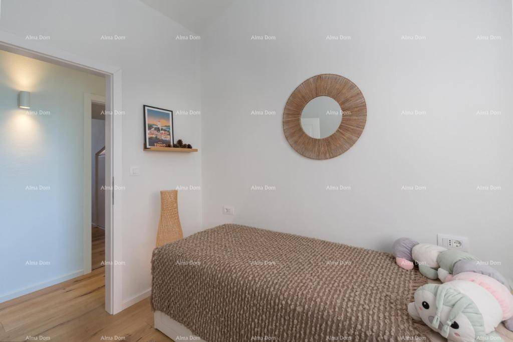 Helles Gästezimmer mit Einzelbett, Holzboden und einem dekorativen runden Spiegel.