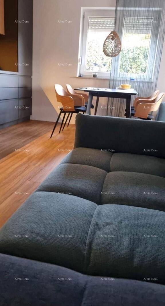 Offener Wohn- und Essbereich mit bequemer Couch, Holzboden und einem Esstisch am Fenster.