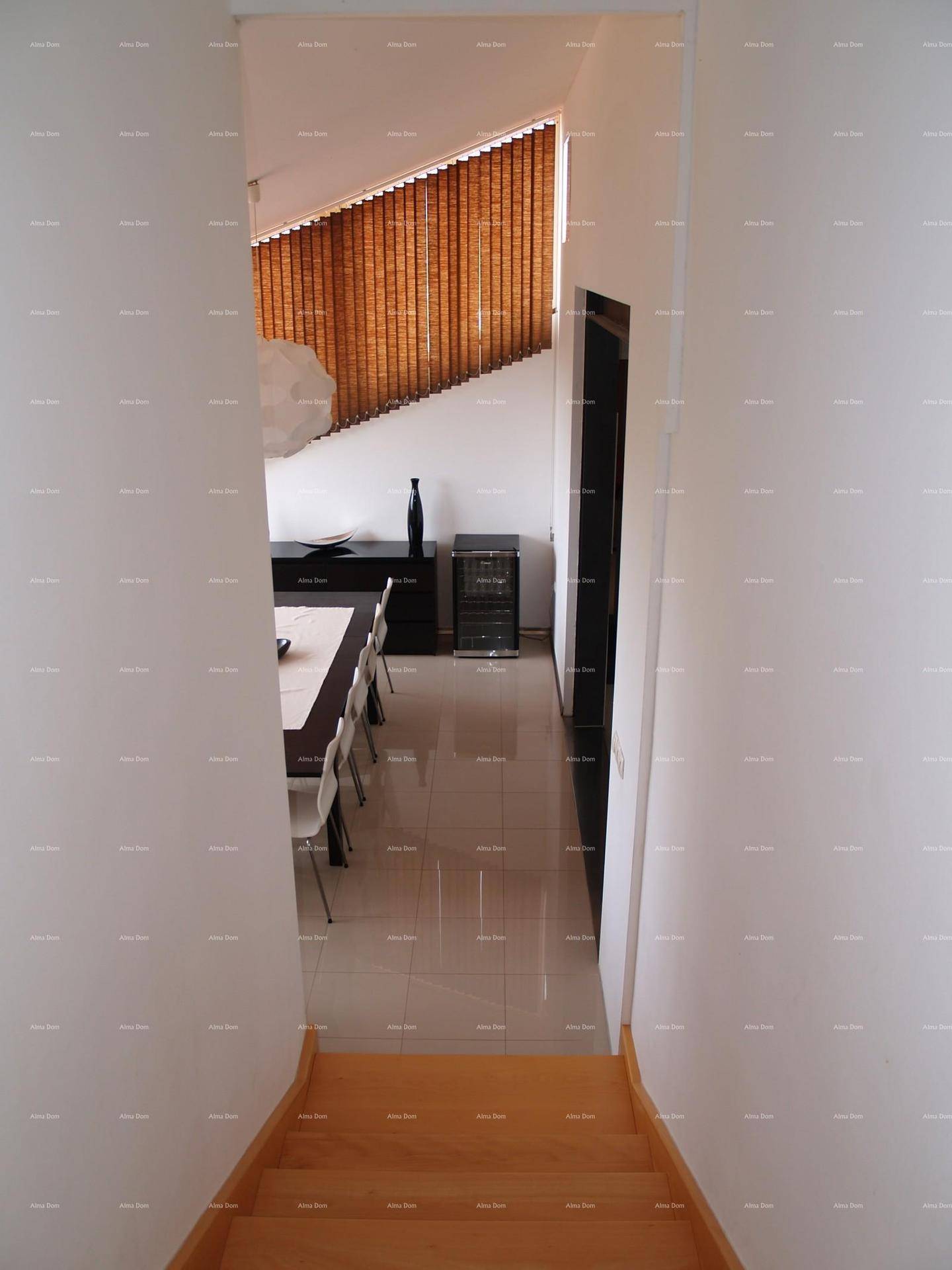 Blick von der Treppe auf den Essbereich mit dunklem Tisch und modernen Stühlen.