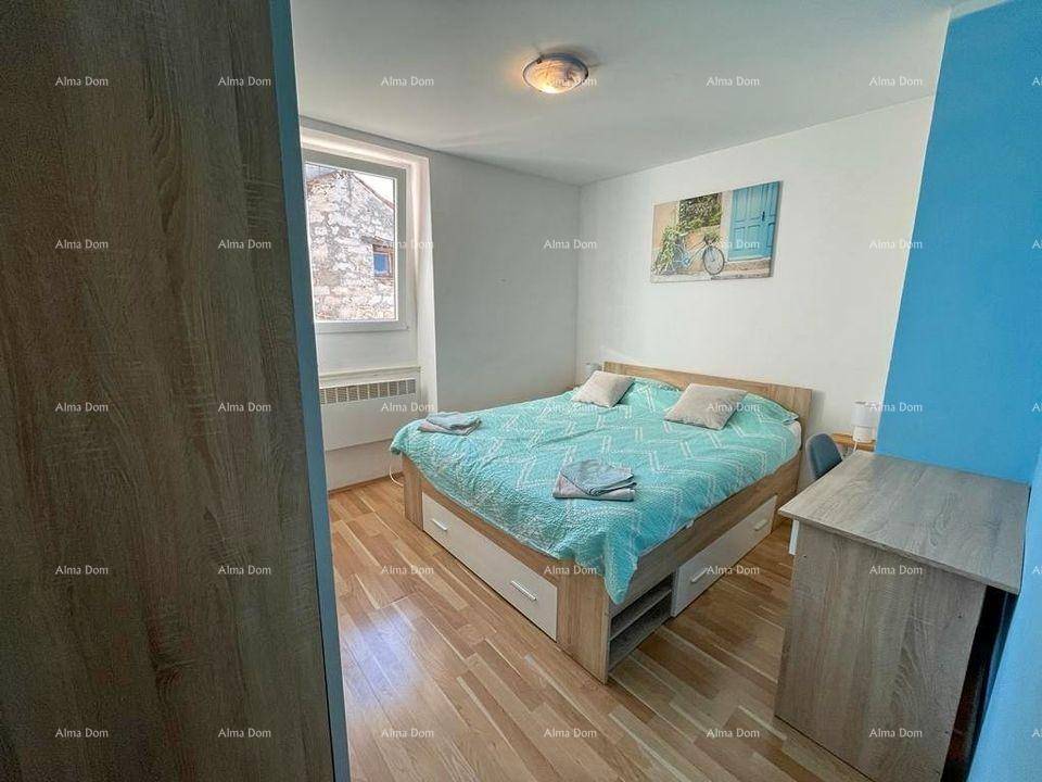 Schlafzimmer mit Doppelbett, Holzfußboden und Fenster mit Blick nach draußen.