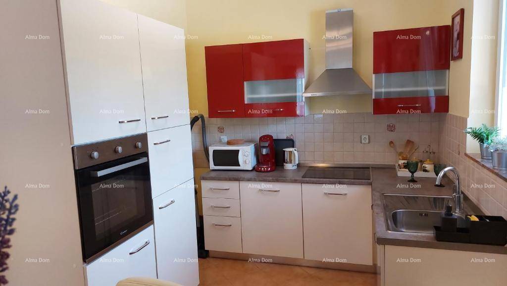 Moderne Küche mit weißen und roten Schränken, integriertem Backofen und Dunstabzugshaube.