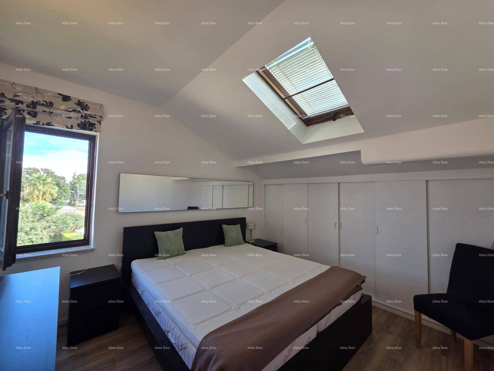 Helles Schlafzimmer im Dachgeschoss mit Doppelbett, Dachfenster und Blick ins Grüne.