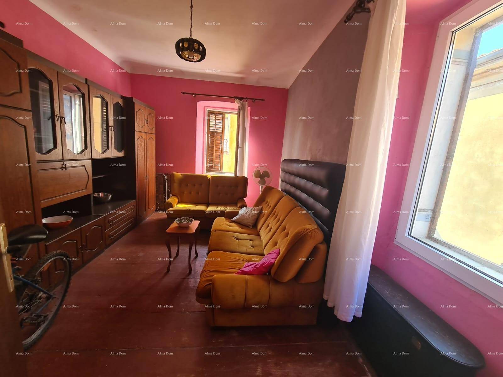Wohnzimmer mit auffälligen pinkfarbenen Wänden, dunklen Holzmöbeln und gelben Sofas.