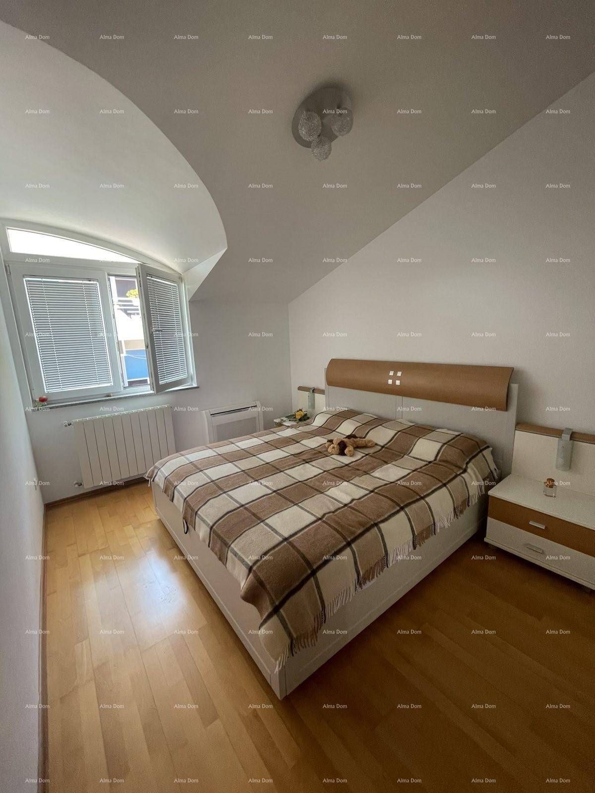 Gemütliches Schlafzimmer mit Holzboden, Doppelbett und Fenster mit Jalousien.