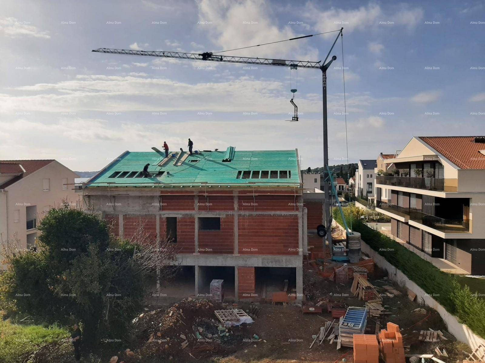 Baustelle eines Hauses mit bereits installierter Dachkonstruktion und Kran im Hintergrund.