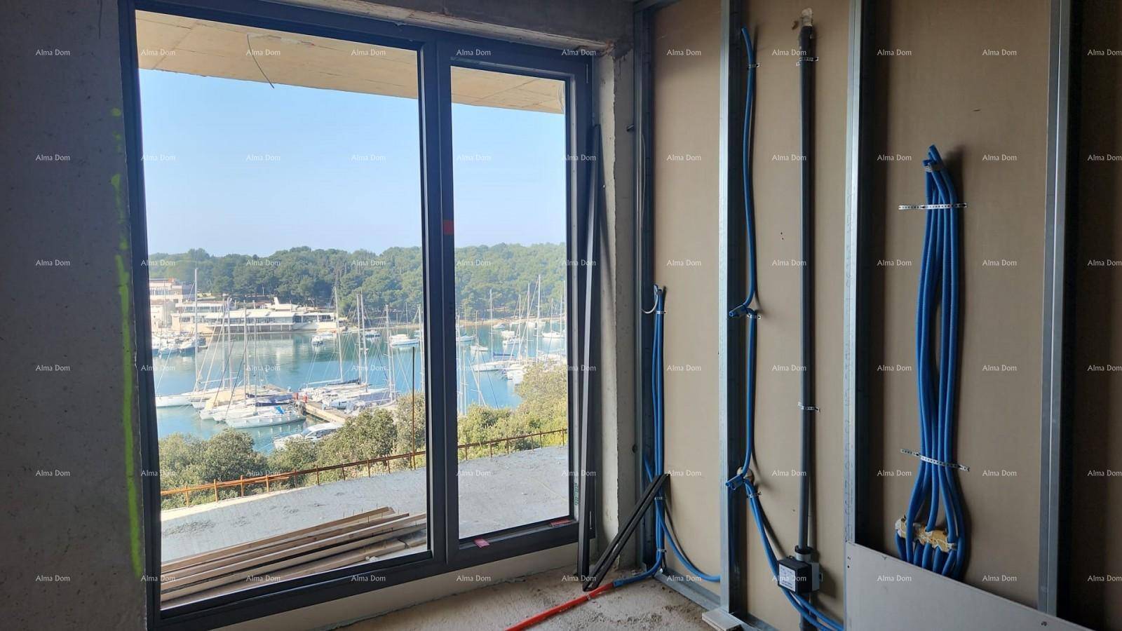 Rohbau eines Zimmers mit sichtbaren Installationen und einem weiten Blick auf den Yachthafen.