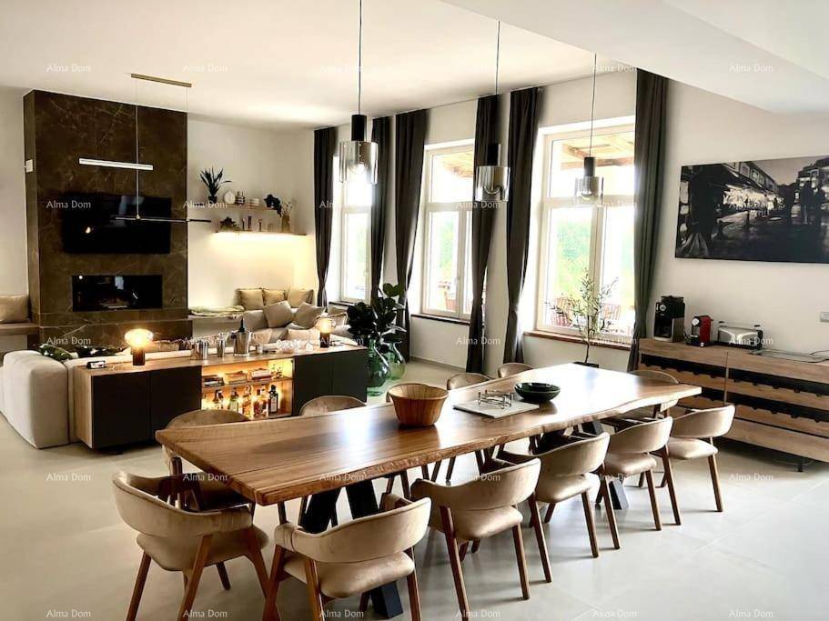 Geräumiger Wohn- und Essbereich mit großem Holztisch und modernem Kamin.