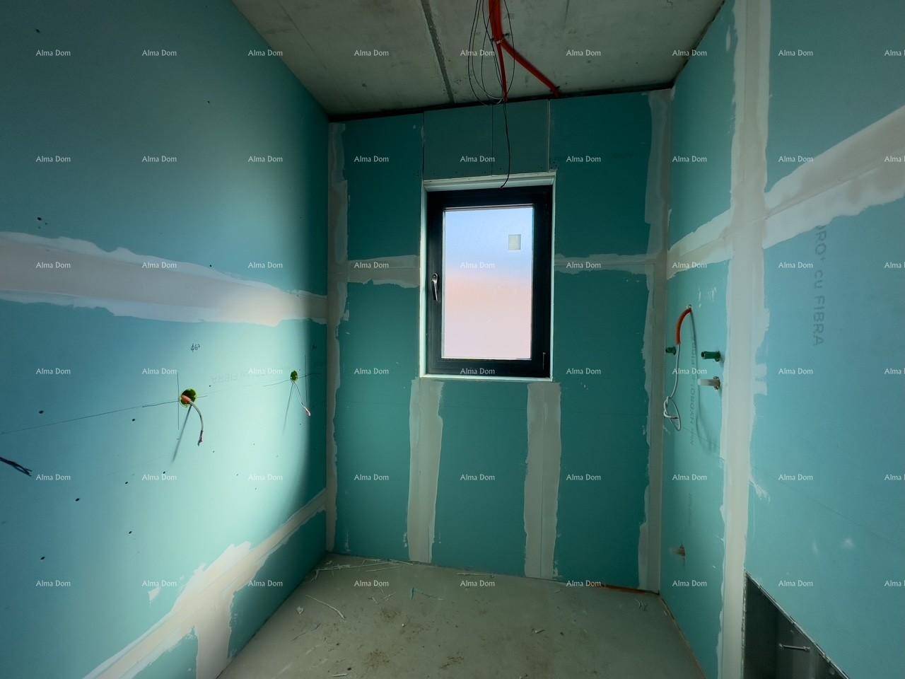 Unfertiges Badezimmer mit blauen Trockenbauwänden und einem Fenster, bereit für die weitere Installation.