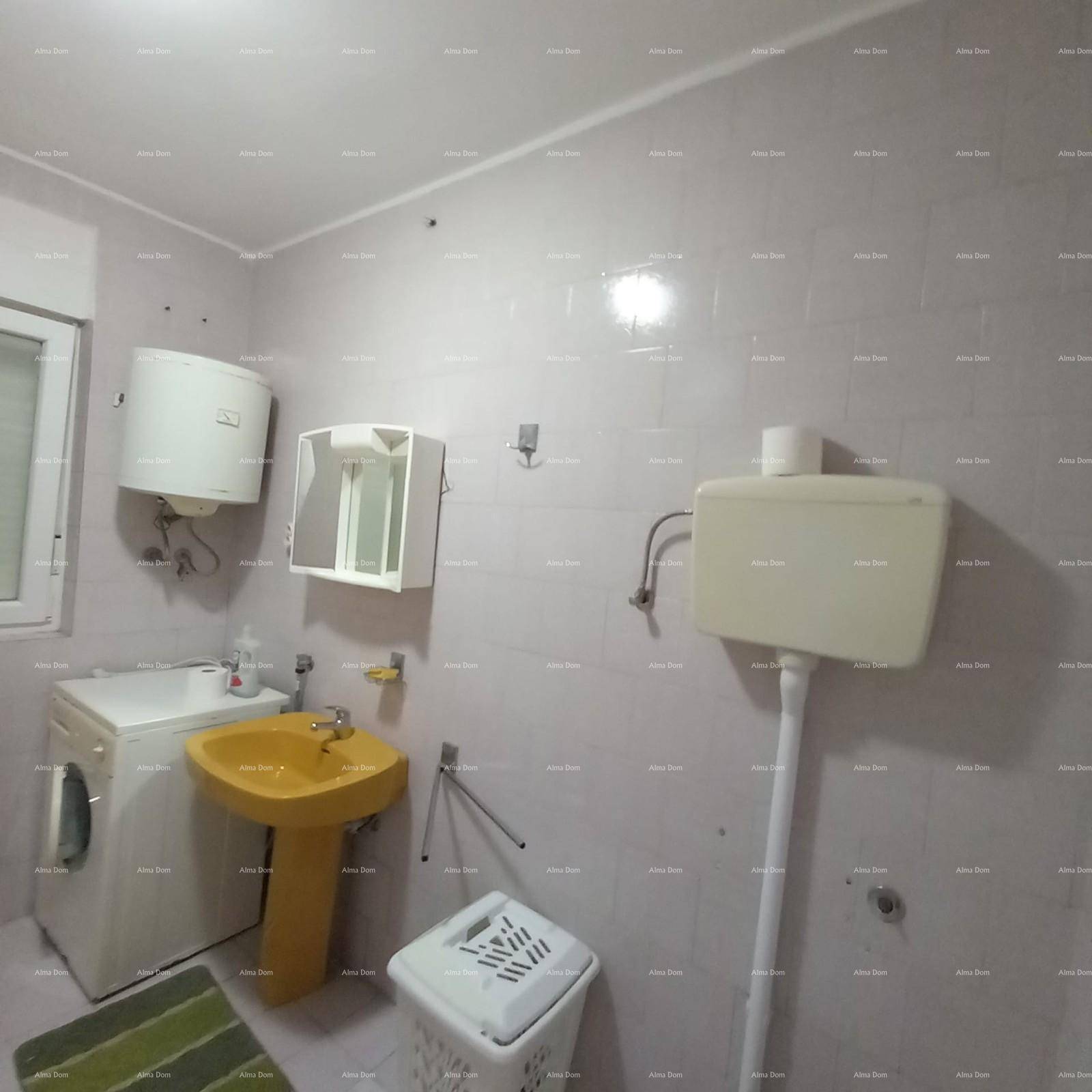 Badezimmer mit Toilette, Waschbecken und Waschmaschine, ausgestattet mit einem Fenster und Boiler.