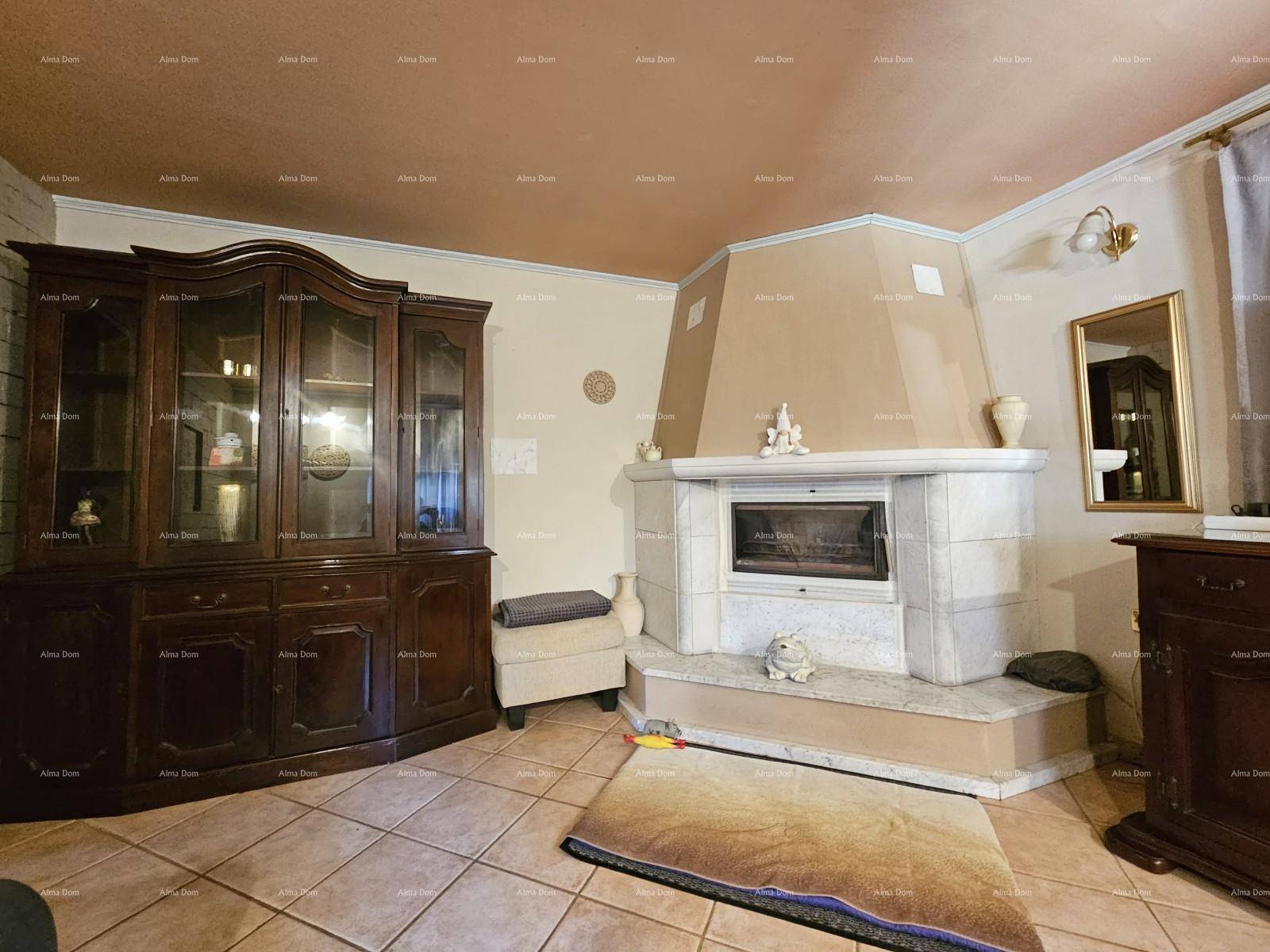 Gemütliches Wohnzimmer mit einem großen Kamin, Fliesenboden und traditionellen Holzmöbeln.