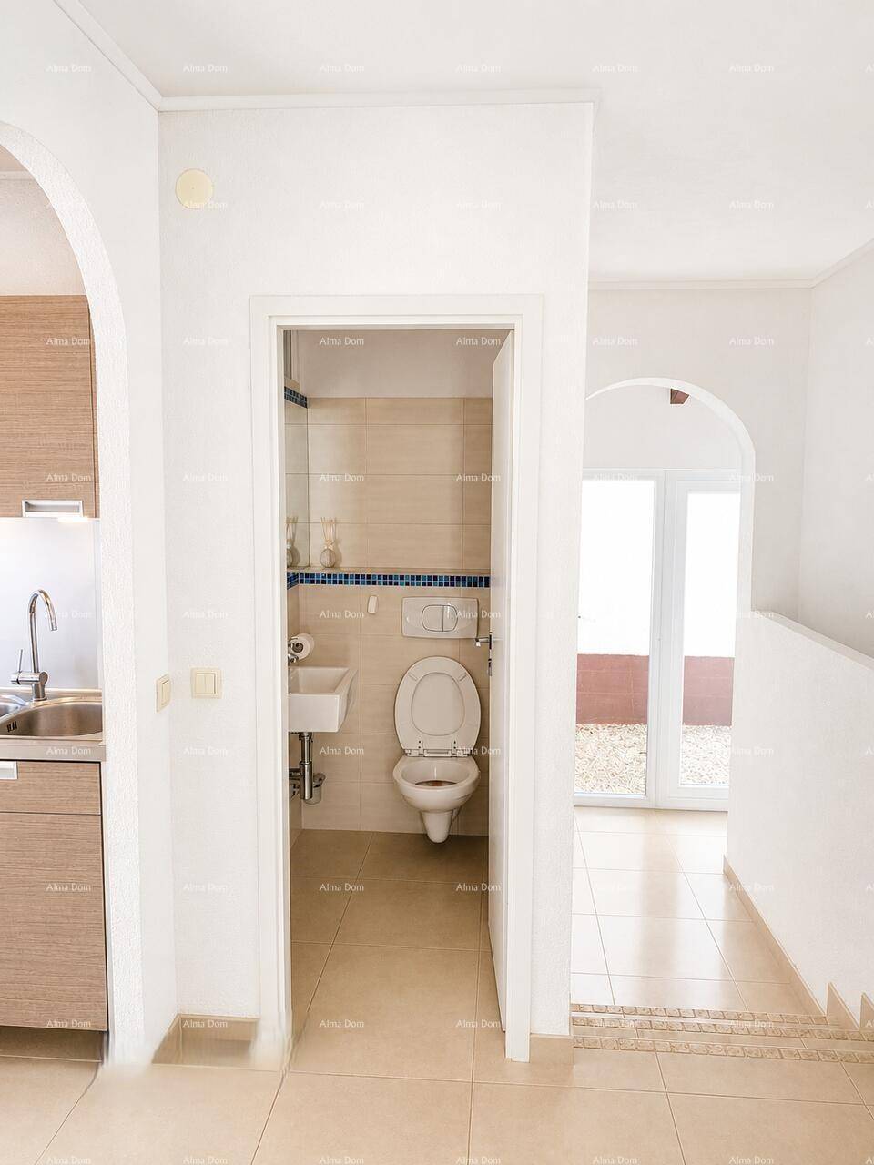 Eingangsbereich zum Gäste-WC mit Blick auf einen weiteren hellen Raum.