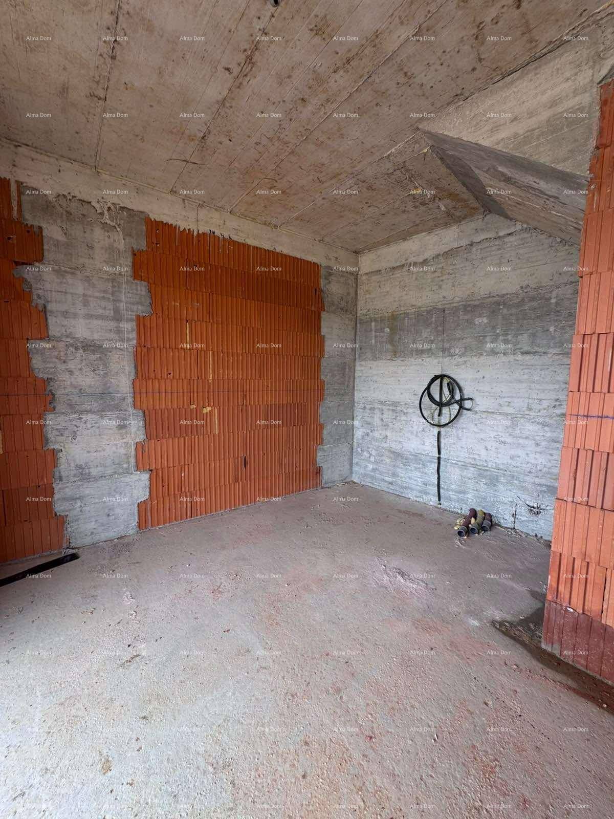 Unfertiger Raum mit einer Mischung aus Beton- und Ziegelwänden und Installationsvorbereitungen.