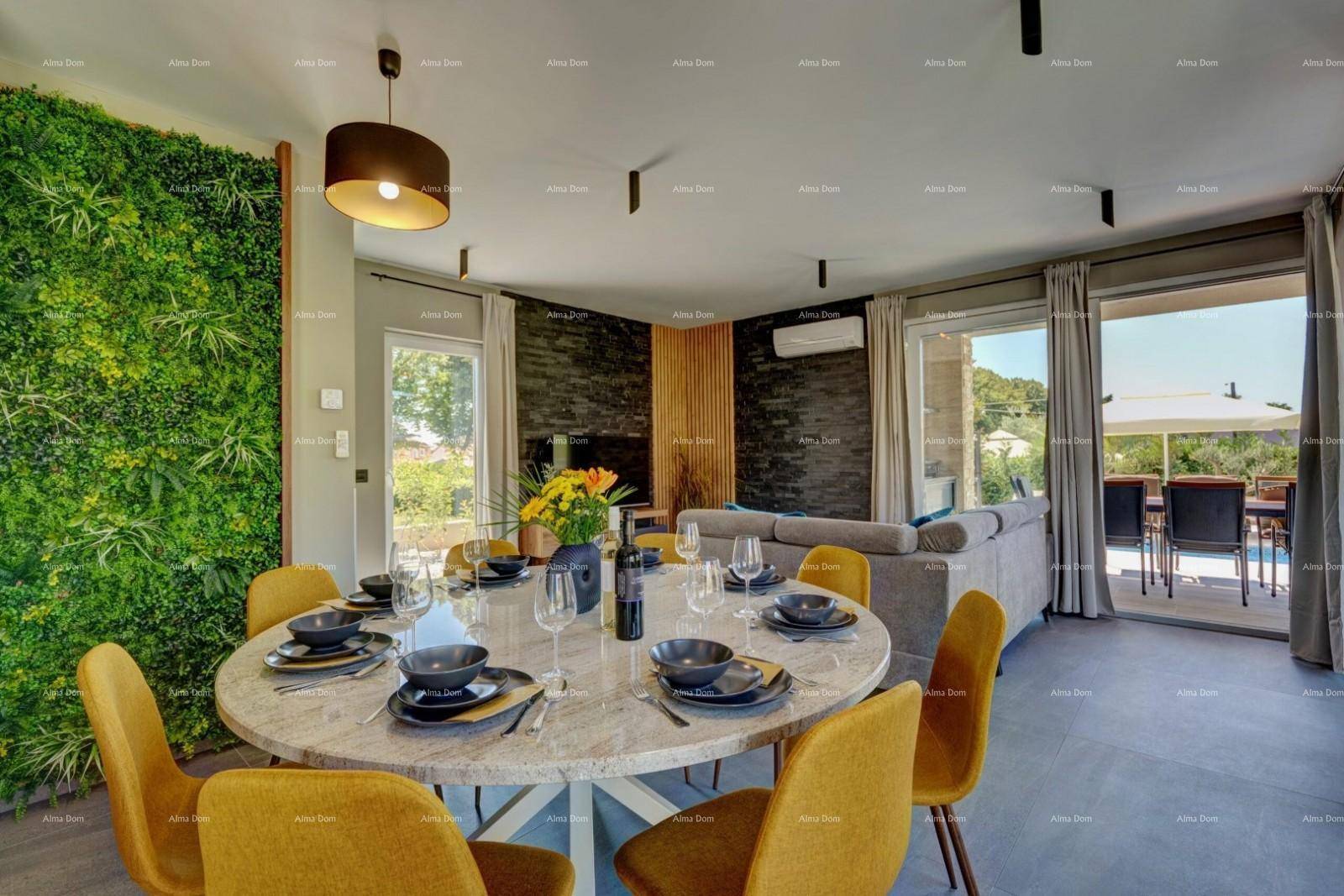 Heller Wohn- und Essbereich mit moderner Einrichtung, grüner Wanddekoration und Terrassenzugang.