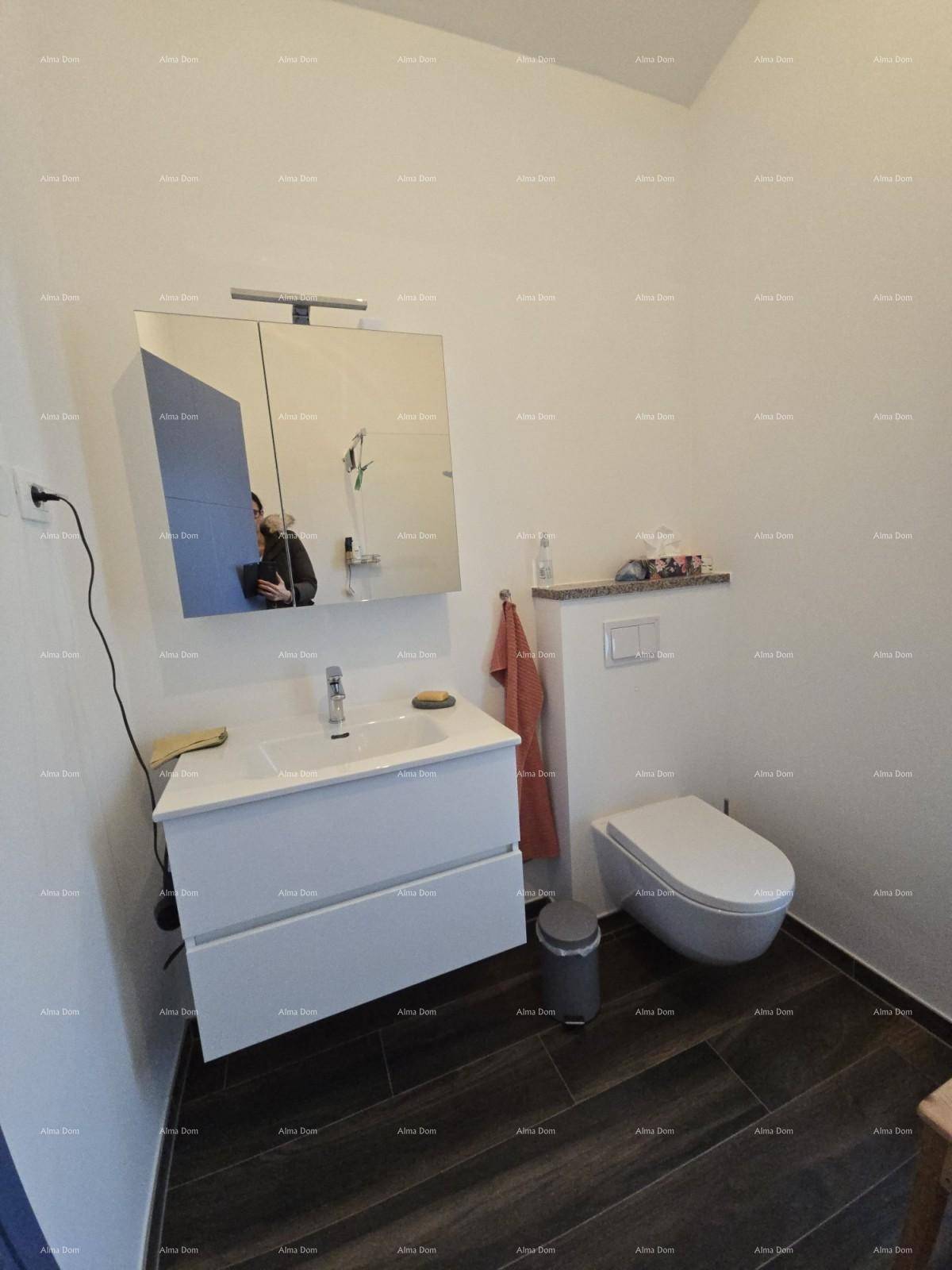 Badezimmer mit modernem Waschtisch, wandhängendem WC und Spiegelschrank.