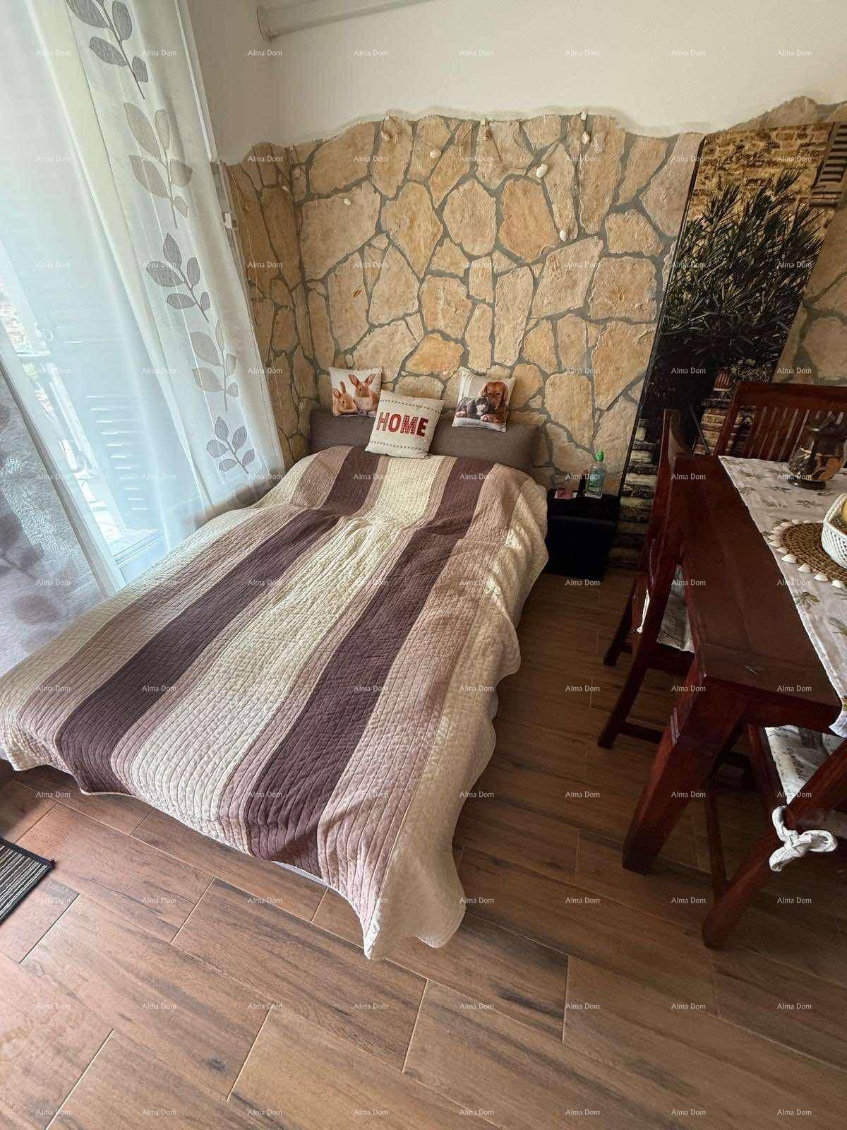 Schlafbereich mit Bett und angrenzendem Essbereich, akzentuiert durch eine dekorative Steinwand.