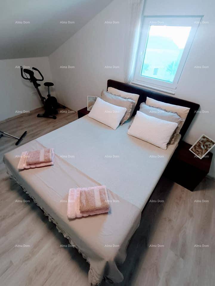 Helles Schlafzimmer mit Doppelbett, Laminatboden und einem Dachfenster für viel Tageslicht.