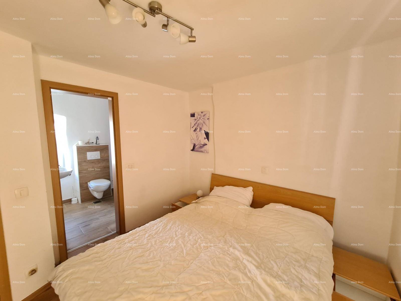 Schlafzimmer mit Doppelbett, Holzboden und Zugang zu einem Badezimmer.