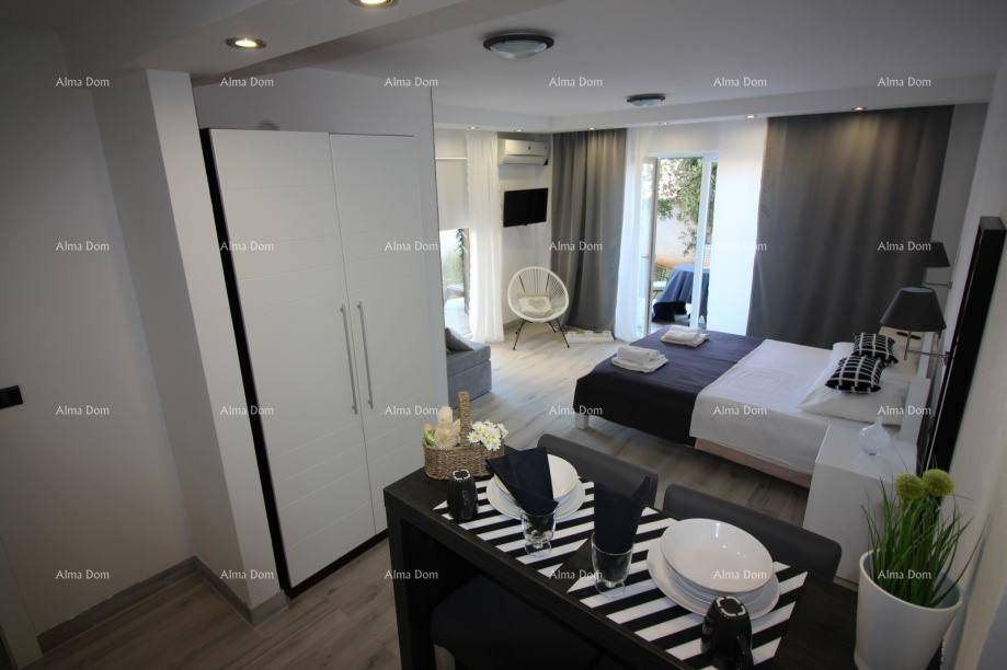 Helles Schlafzimmer mit Doppelbett, Kleiderschrank und Essbereich, mit Balkonzugang.