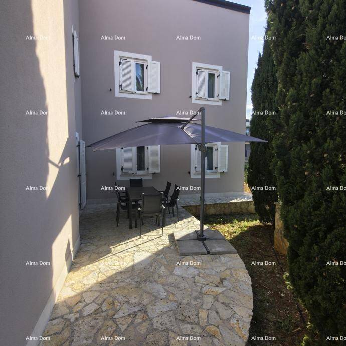 Sonniger Terrassenbereich mit Esstisch, Sonnenschirm und Blick ins Grüne.