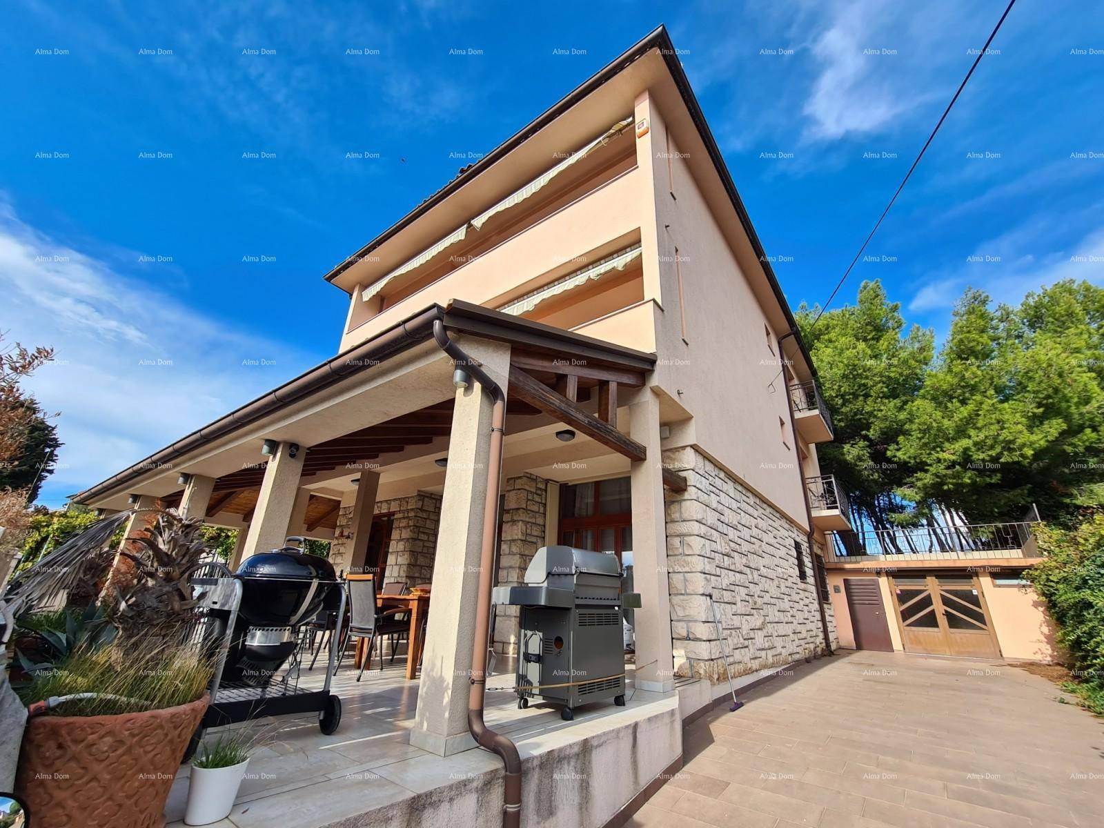 Überdachte Terrasse mit Steinfassade und Grillbereich, ideal für Mahlzeiten im Freien.
