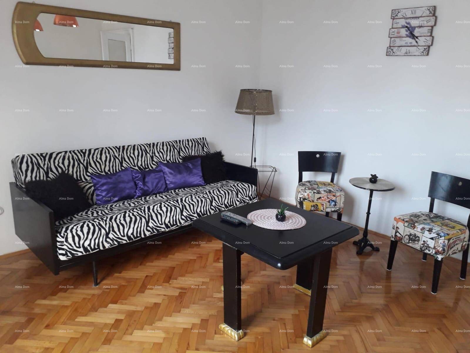 Gemütliches Wohnzimmer mit Fischgrätparkett, Zebra-Sofa und modernem Couchtisch in Schwarz.