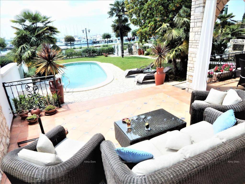 Geräumige Terrasse mit bequemen Sitzgelegenheiten, Pool und Blick auf das Meer und den Hafen.