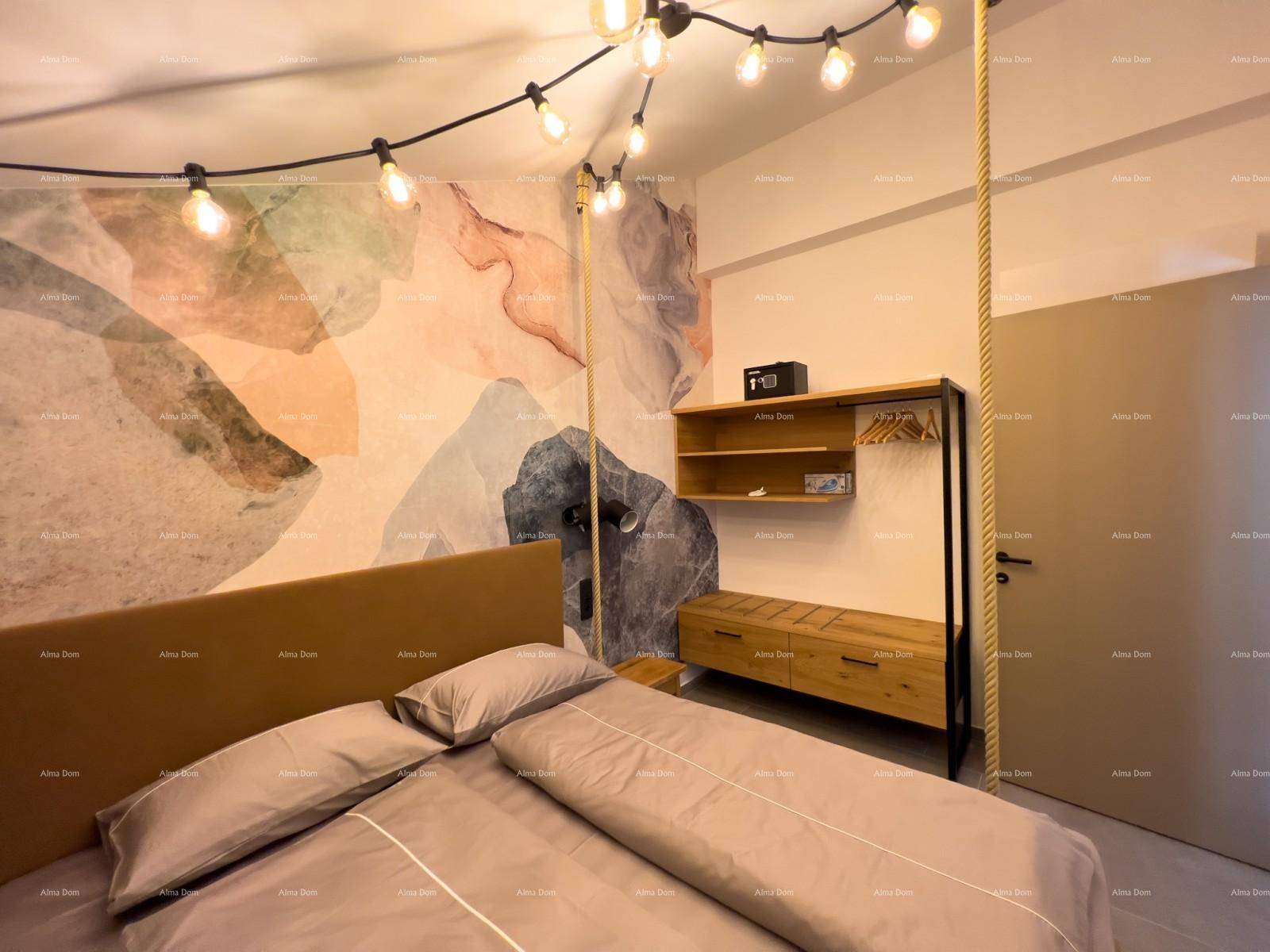 Schlafzimmer mit Holzbett, offener Garderobe und farbiger Wandgestaltung im Dachgeschoss.
