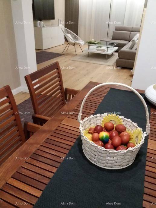 Essbereich mit Holztisch und Blick auf das helle Wohnzimmer mit Sofa.