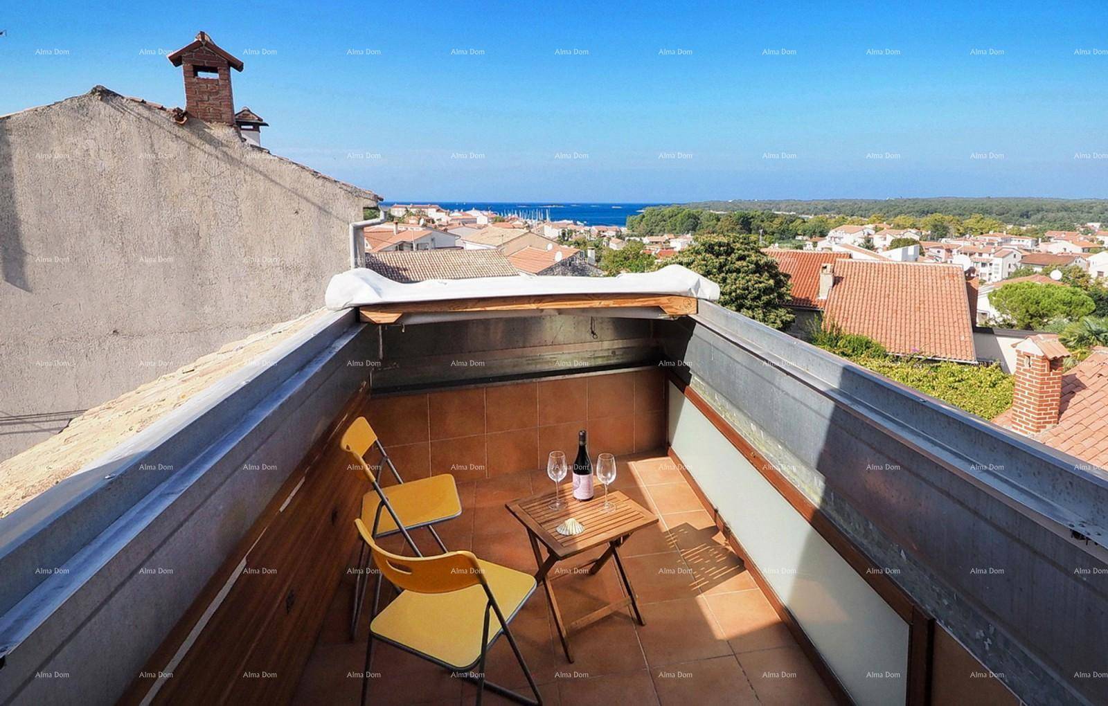 Kleiner Dachbalkon mit Sitzgelegenheiten und weitem Blick über die Stadt und das Meer.