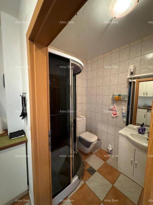 Badezimmer mit Duschkabine, WC und Waschbecken, durch einen Türrahmen sichtbar.
