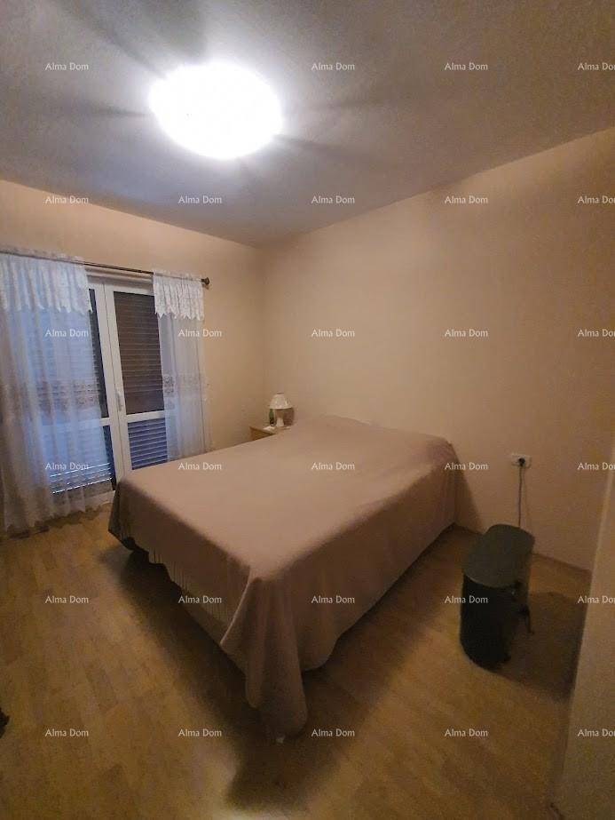 Schlafzimmer mit Doppelbett, Holzboden und Zugang zu einem Balkon oder einer Terrasse.