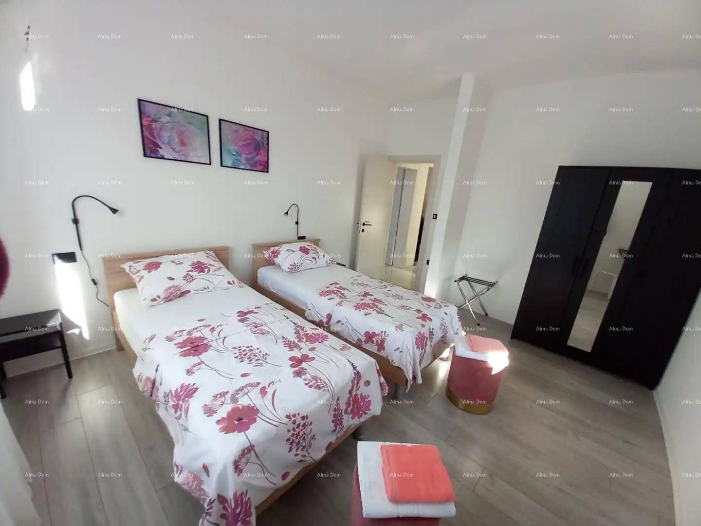 Helles Schlafzimmer mit zwei Einzelbetten, modernem Laminatboden und farbigen Akzenten.