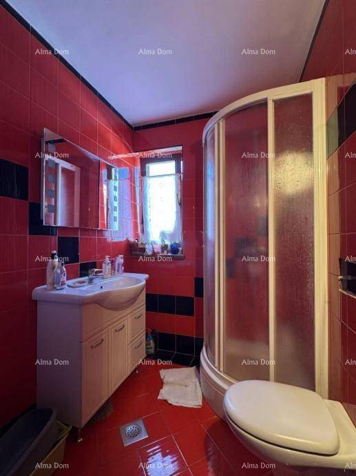 Badezimmer mit roten Fliesen, Duschkabine, Einzelwaschbecken und Fenster für Tageslicht.