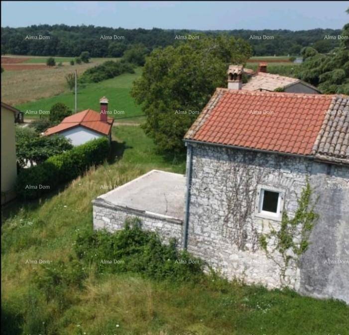 Altes Steinhaus mit Ziegeldach und weitem Blick über die ländliche Landschaft und grüne Felder.