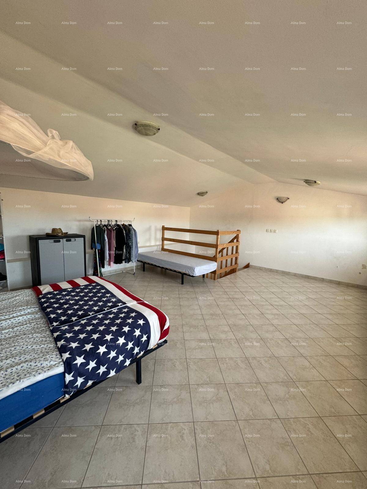 Weitläufiges Schlafzimmer im Dachgeschoss mit Fliesenboden und einfacher Einrichtung, ideal für Gäste.