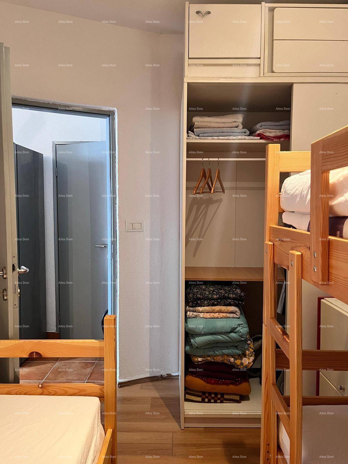 Schlafzimmer mit Etagenbetten und einem praktischen offenen Kleiderschrank für Kleidung und Handtücher.