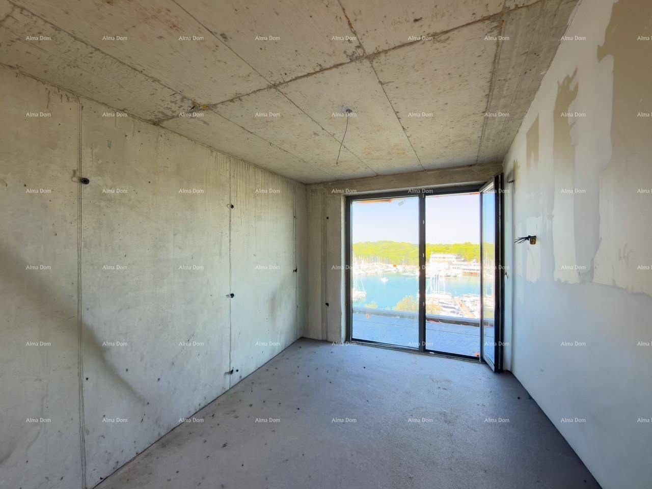 Unfertiger Raum mit Betonwänden und großen Schiebetüren, die einen Blick auf den Yachthafen bieten.