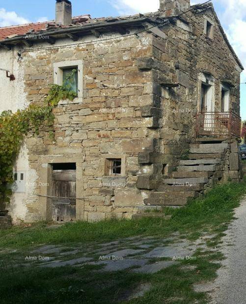 Traditionelles Steinhaus mit rustikaler Fassade, Außentreppe und Holztüren in ländlicher Umgebung.
